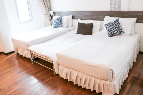 two beds in a room with wood flooring at The Mini R Ratchada in Bangkok
