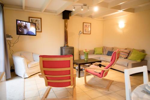 a living room with a couch and a table and chairs at Zeepark Zeewind in Bredene