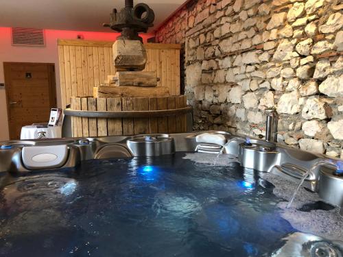 a hot tub in a room with a water fountain at Les Villas du Domaine de Suzel in Vignieu