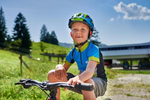a young boy is sitting on a bike at Alpe Oberstdorf in Oberstdorf