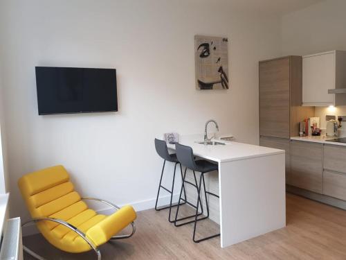 a kitchen with a table and chairs and a sink at 34 Cuppin Street - luxury city centre apartment! in Chester