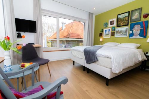 een slaapkamer met een bed, een tafel en een raam bij Boutiquehotel B&B the SJinn in Schin op Geul