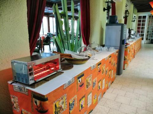 a table with a counter top with a microwave on it at Hotel Jardin Savana Dakar in Dakar