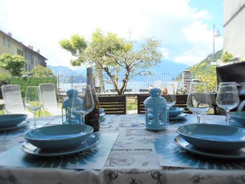 a table with blue plates and wine glasses on it at GAIA in Lierna