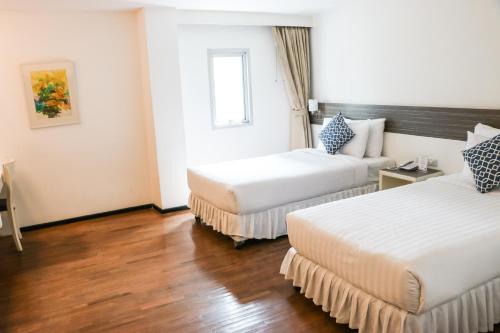 a hotel room with two beds and a window at The Mini R Ratchada in Bangkok