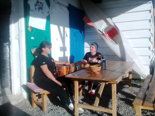 two women sitting at a wooden table in a room at My home udabno in Udabno