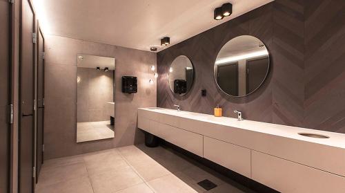 a bathroom with a sink and a mirror and a shower at Comfort Hotel Victoria Florø in Florø