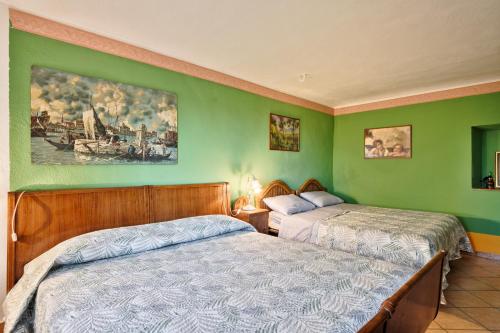 two beds in a room with green walls at Splendido rustico nella Langa in Clavesana