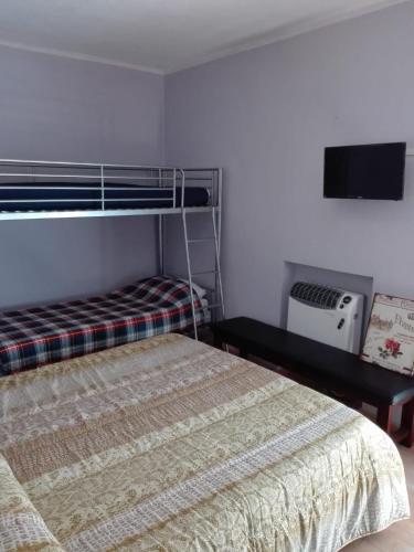 a bedroom with a bunk bed and a tv at Il posto del ciliegio selvatico in Cavaliere
