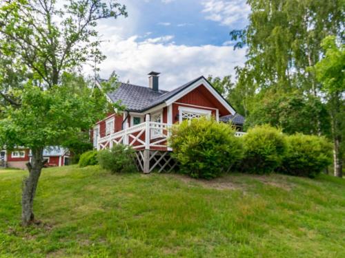 ein rotes Haus mit einer Veranda auf einem grünen Rasen in der Unterkunft Holiday Home Lilla nennebo by Interhome in Förby