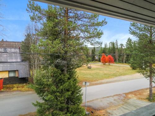 a window view of a yard with two red trees at Holiday Home Kanerva 202 by Interhome in Äkäslompolo