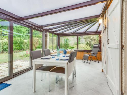 une véranda avec une table et des chaises blanches dans l'établissement Holiday Home Le Pré Verger-3 by Interhome, à Villers-sur-Mer