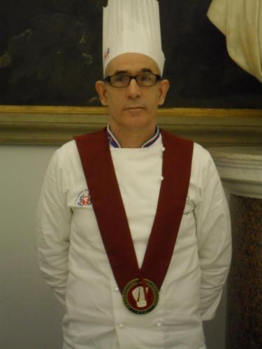 a man in a chefs hat with a medal around his neck at Hotel Sagittario in San Sperate