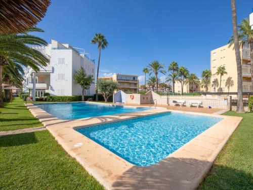 una piscina en un patio con palmeras en Apartment La Senia by Interhome, en Denia