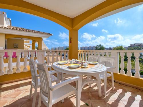 - Balcón con mesa blanca y sillas en Apartment Playasol II by Interhome, en Denia