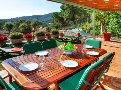 a wooden table with a bowl of fruit on a patio at Holiday Home Gloria by Interhome in Calonge