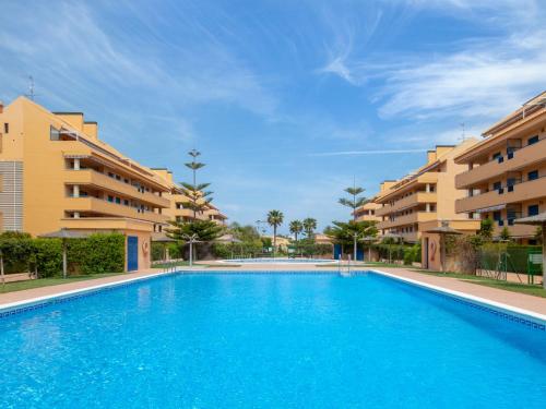 a swimming pool in front of some apartment buildings at Apartment La Marjal-3 by Interhome in Denia