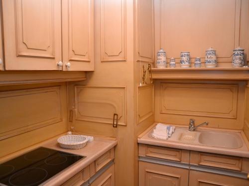 a kitchen with wooden cabinets and a sink and a counter at Haus Schaper in Westerland