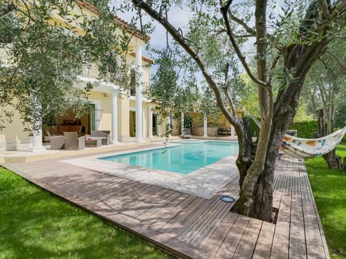 - une piscine dans une cour avec un hamac à côté d'un arbre dans l'établissement Villa Caliopa by Interhome, à Grasse