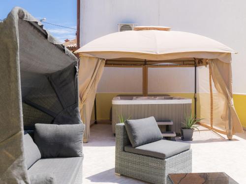patio z 2 krzesłami i parasolem w obiekcie Holiday Home Evelina by Interhome w mieście Ližnjan