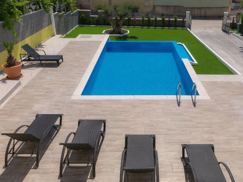 basen z kilkoma krzesłami obok niego w obiekcie Holiday Home Evelina by Interhome w mieście Ližnjan