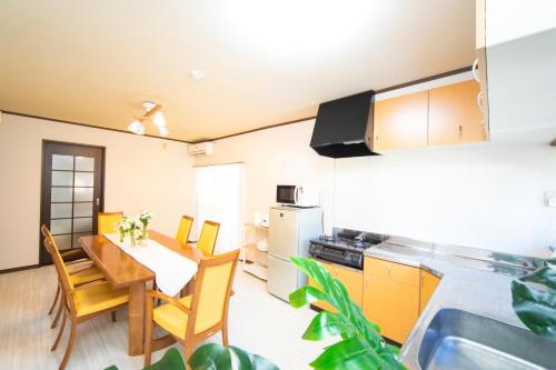 a kitchen and dining room with a table and chairs at Yokkaichi egaosakuie in Shimizucho 1 in Yokkaichi