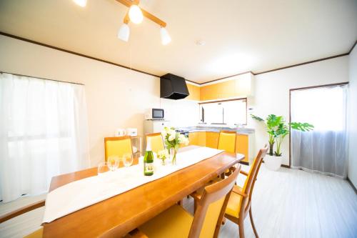 a dining room with a long table and chairs at Yokkaichi egaosakuie in Shimizucho 1 in Yokkaichi