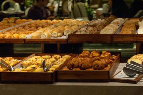 a bakery filled with lots of different types of pastries at Grand Mercure Curitiba Rayon in Curitiba