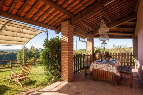 a patio with a table and chairs under a roof at Splendido rustico nella Langa in Clavesana