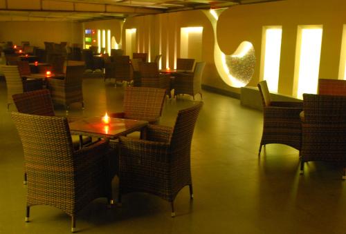 a dining room with tables and chairs and lights at The Roa Hotel in Mumbai