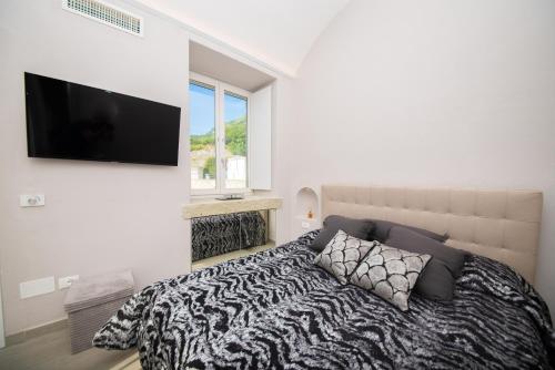 a bedroom with a bed with a television on the wall at Tenuta C'est la Vie in Ischia