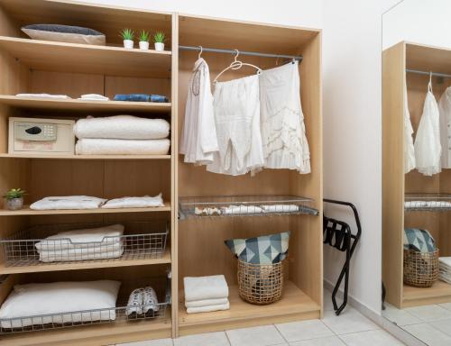 a wardrobe with white clothes and towels in a room at ApartHotel Okeanos on the Beach in Herzliya