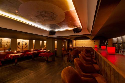 a restaurant with tables and chairs and a bar at Hotel Arte in St. Moritz