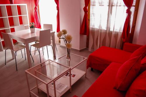 a living room with a red couch and a table at Nest Style Granada in Granada