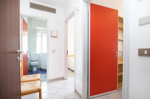 a bathroom with a toilet and a red door at Residence San Francisco in Marina di Andora
