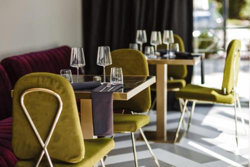 a dining room with a table and chairs with wine glasses at Amsterdam Plaza Hotel & SPA in Palanga
