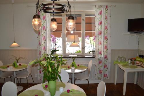 ein Esszimmer mit Tischen, Stühlen und einem Fenster in der Unterkunft Hotell City in Hässleholm