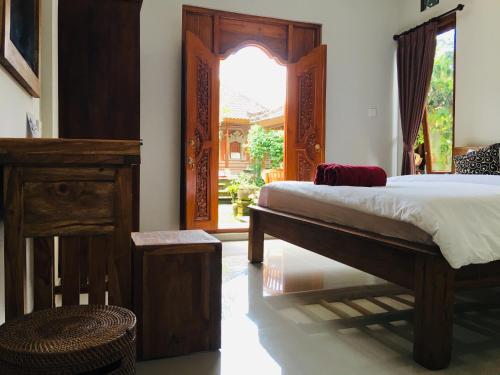a bedroom with a bed and a large window at Wina Ubud B&B in Ubud