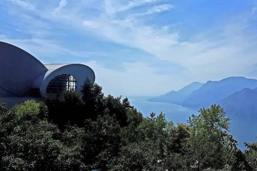 a building on top of a hill with trees at Villa sul Lago con pontile privato a Brenzone sul Garda - Unique and exclusive in Brenzone sul Garda