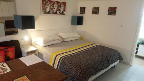 um pequeno quarto com uma cama e uma mesa em Location Turistic Monolocale nel Parco del Santuario CIR 00033 em Asti
