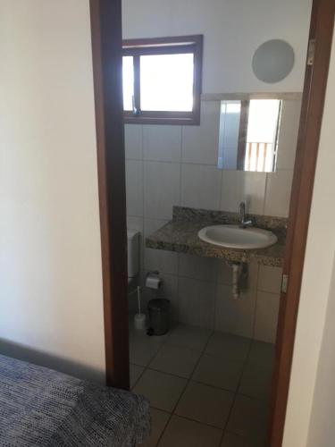 a small bathroom with a sink and a mirror at Club house in Prainha