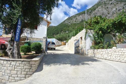a car parked on a road next to a stone wall at Locanda Barbati Luxury ApartHotel in Barbati