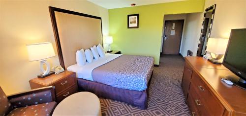 a hotel room with a bed and a flat screen tv at Travel Inn and Suites- Sikeston Miner I-55 exit-67 in Sikeston