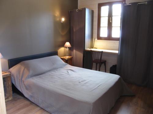 a bedroom with a bed and a window and a desk at La Saline in Le Palais
