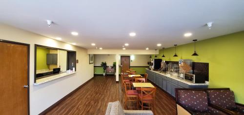 a restaurant with green walls and a bar with chairs at Travel Inn and Suites in Sikeston