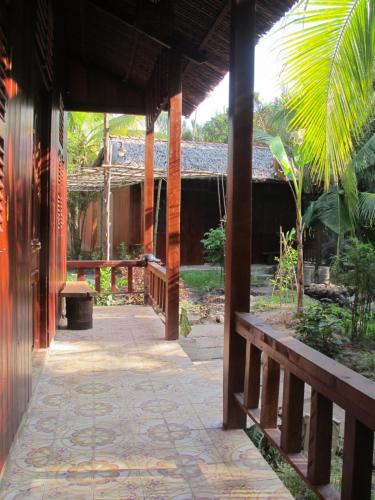 a walkway outside of a building with a porch at Ben Tre Farm Stay in Ben Tre