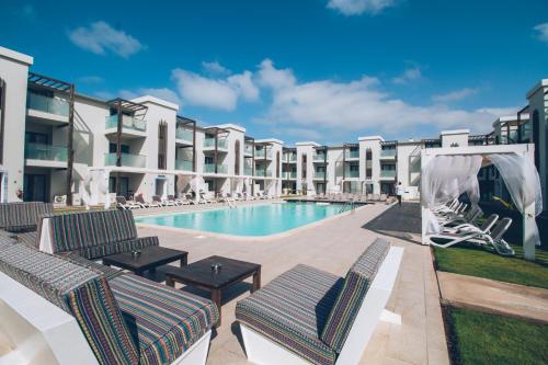 uma piscina com espreguiçadeiras ao lado de um edifício em Halos Casa Resort em Santa Maria