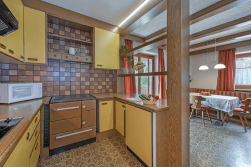 a kitchen with yellow cabinets and a dining room at Mühlheim in Anterselva di Mezzo