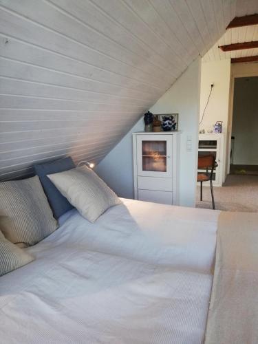 a bedroom with a large white bed and a desk at Tankefuld Living's Horsefarm in Svendborg