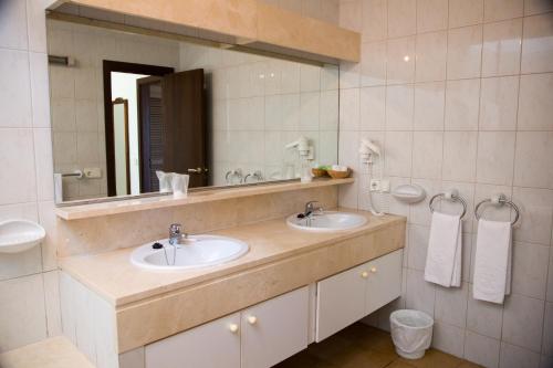 a bathroom with two sinks and a large mirror at Apartamentos Parque Mar in Cala d´Or